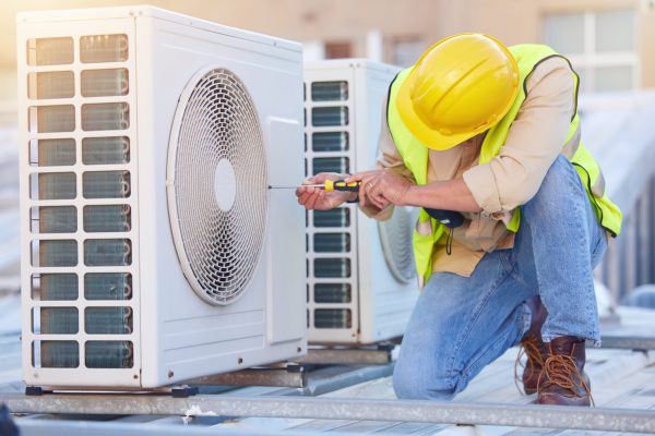 Air conditioning, technician or engineer on roof for maintenance, building or construction of fan hvac repair. Air conditioner, handyman or worker with tools working on a city development project job.